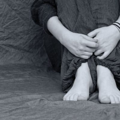 legs of a sad person sitting on floor